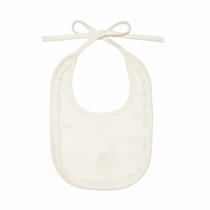 Cream baby bib with bow vertical flat lay