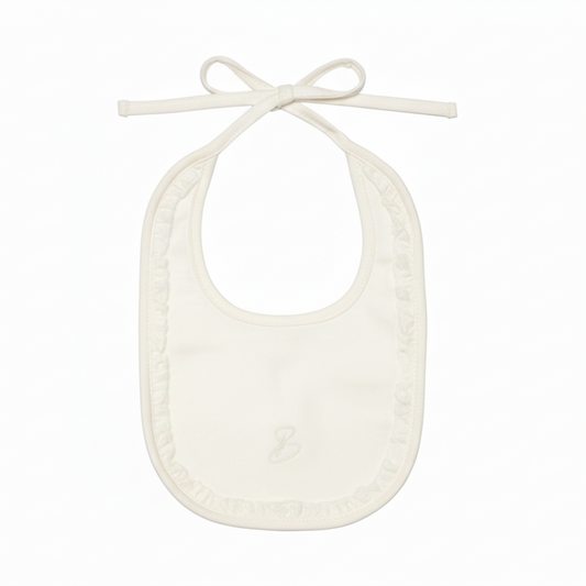 Cream baby bib with bow vertical flat lay